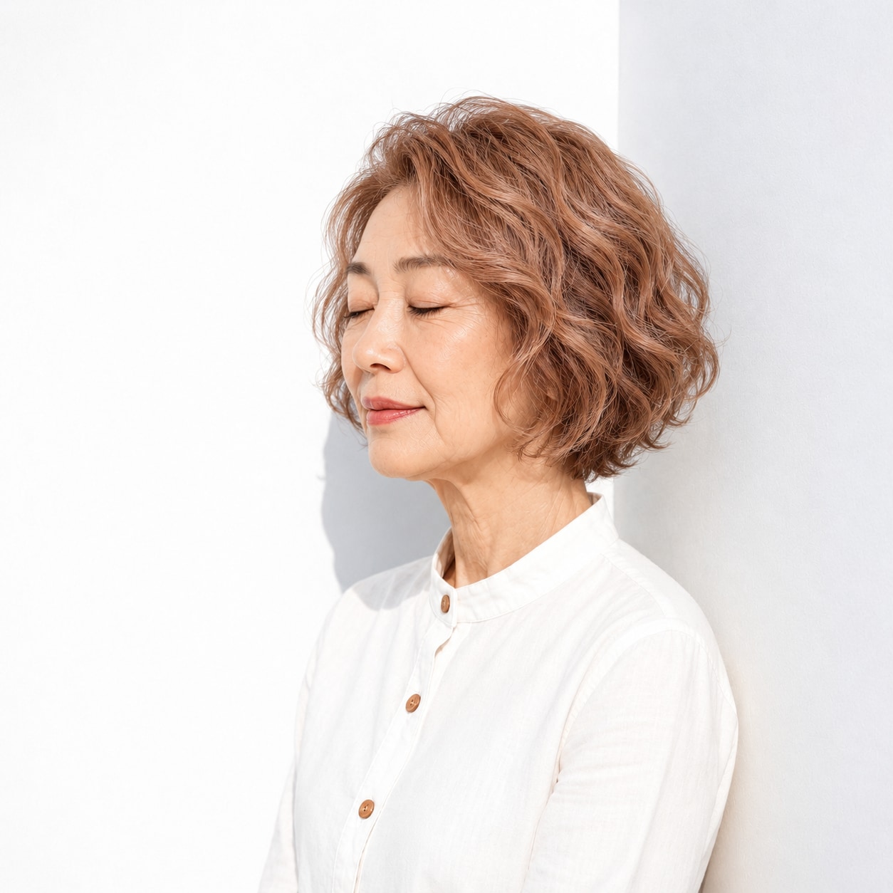 2. ショートボブパーマ × 明るめブラウン：大きなうねりが横顔を彩る
